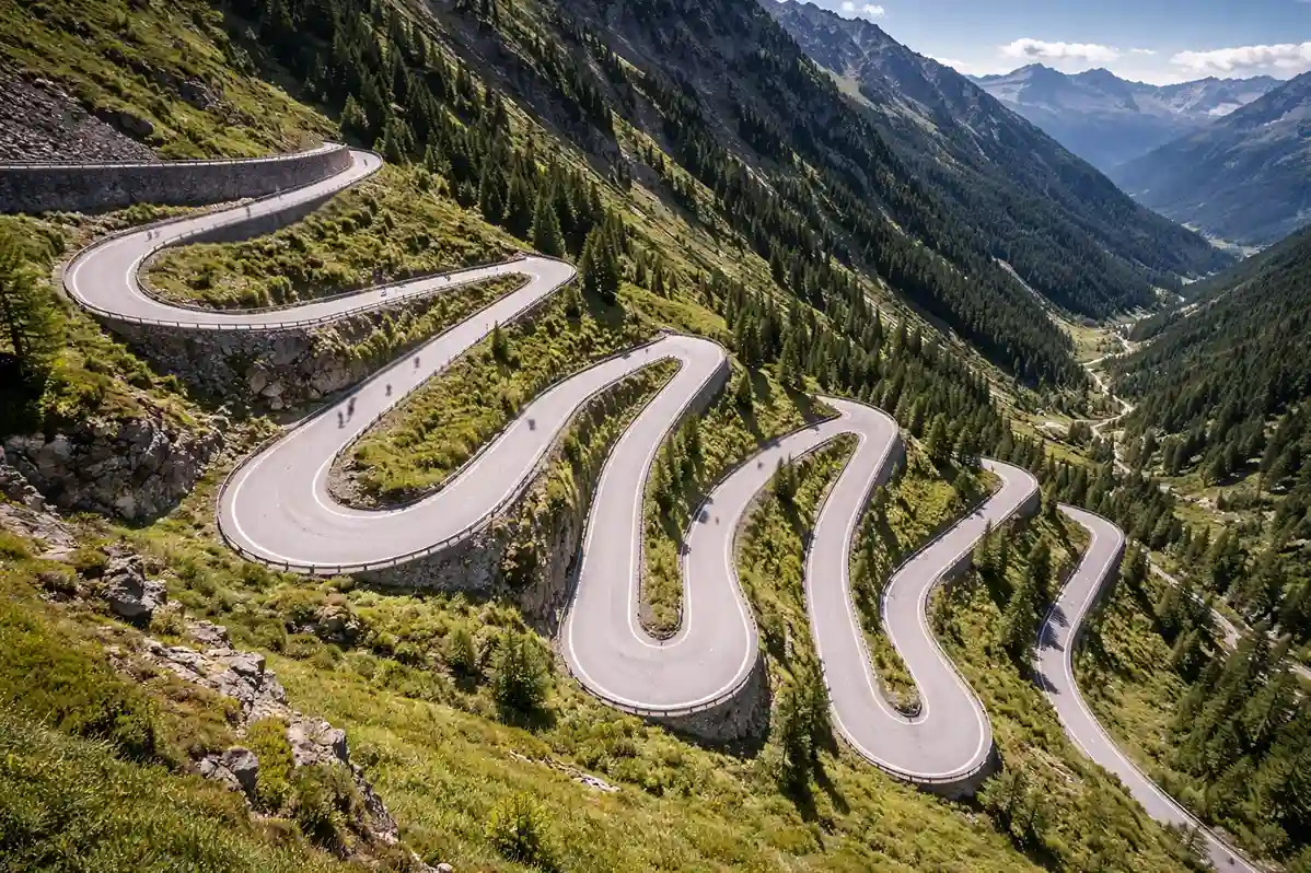 Strada di montagna con tornanti vista dall'alto, percorso di una tappa ciclistica tra valli verdi