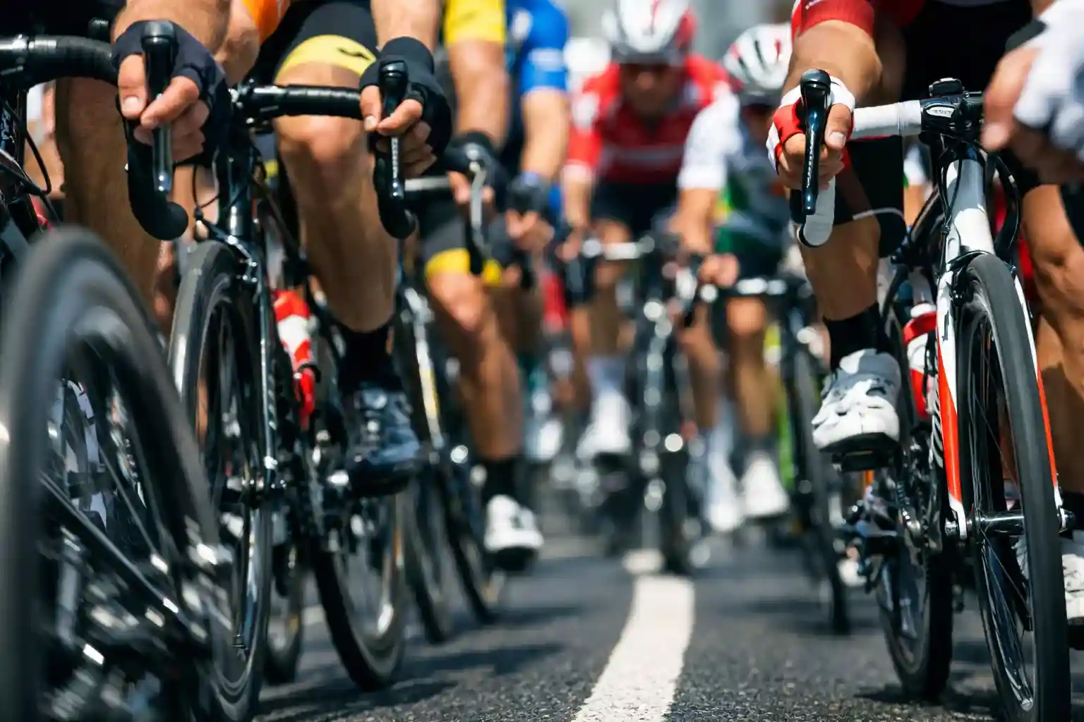 Primo piano di un gruppo compatto di ciclisti professionisti visto da vicino durante una corsa su strada
