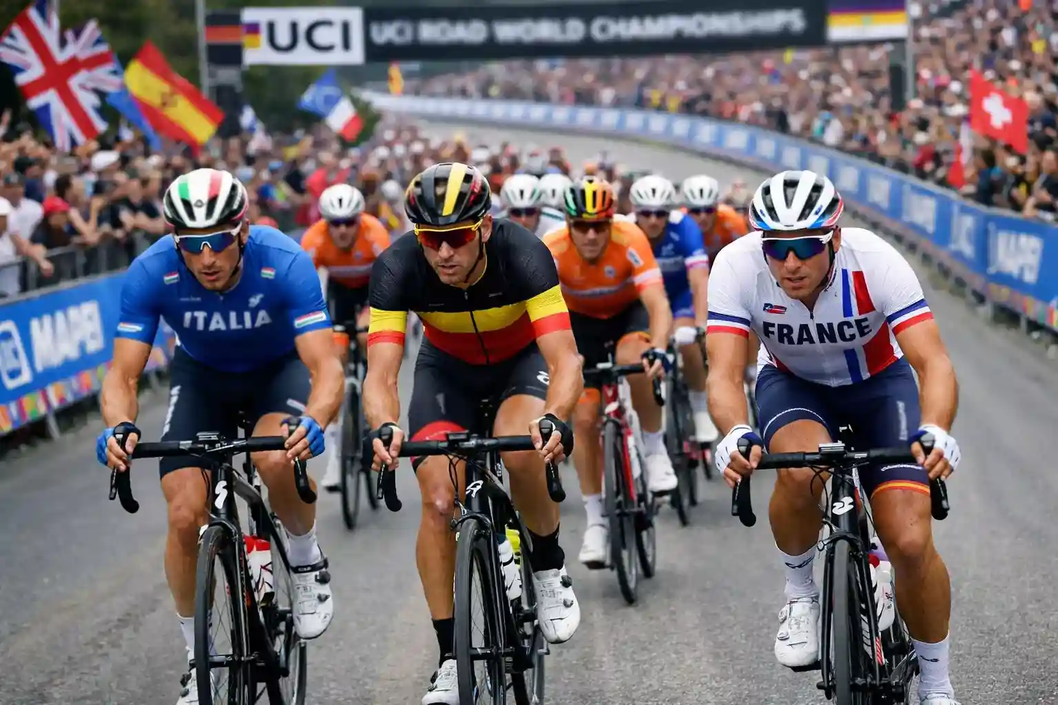 Ciclisti con maglie delle squadre nazionali in gara su un circuito dei Campionati del Mondo